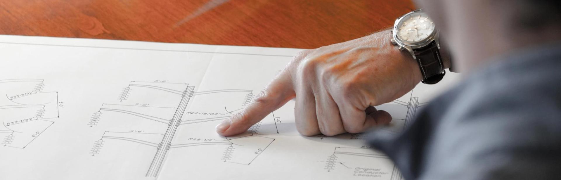 hand pointing to blueprint